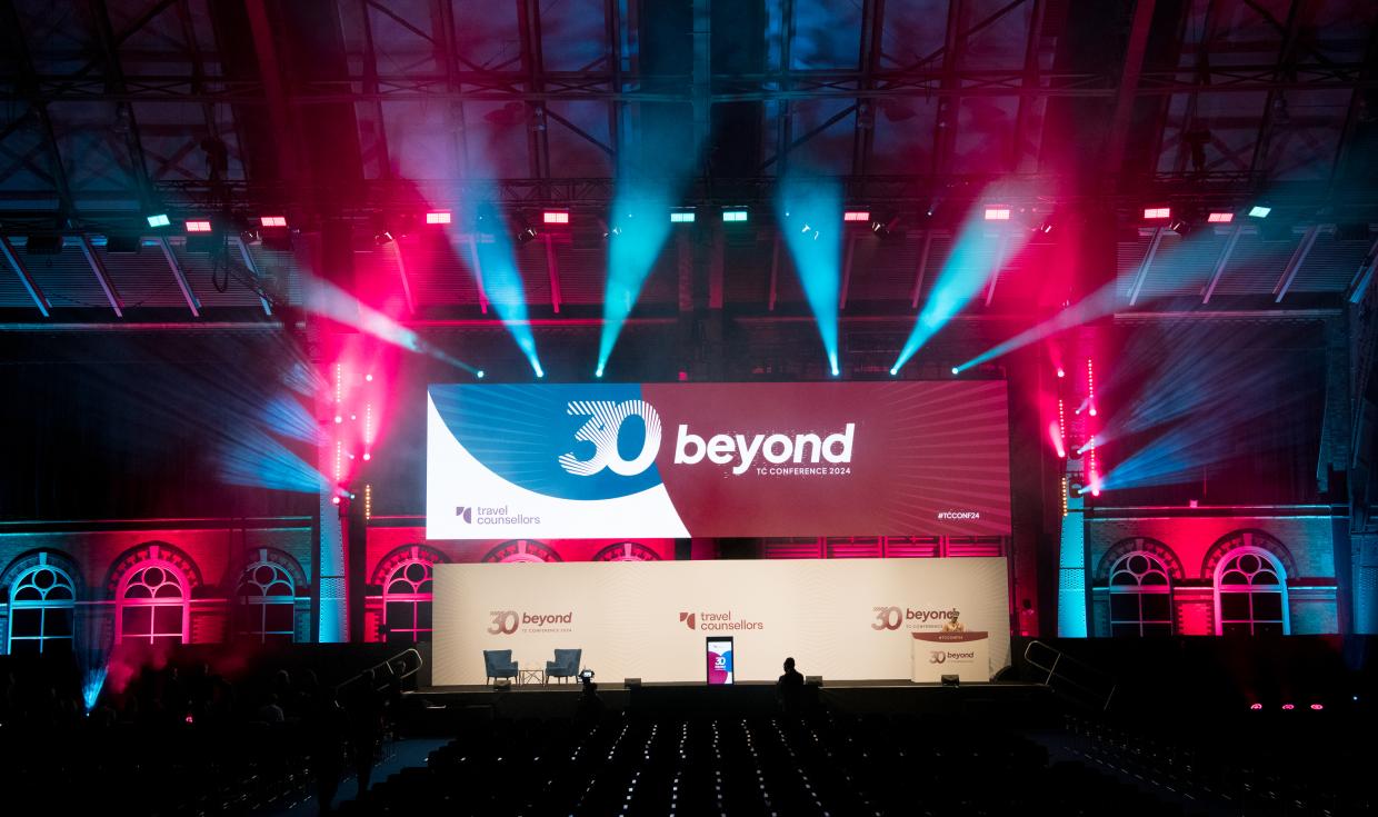 Large stage lit up with pink and blue lighting, with a screen reading 30 beyond